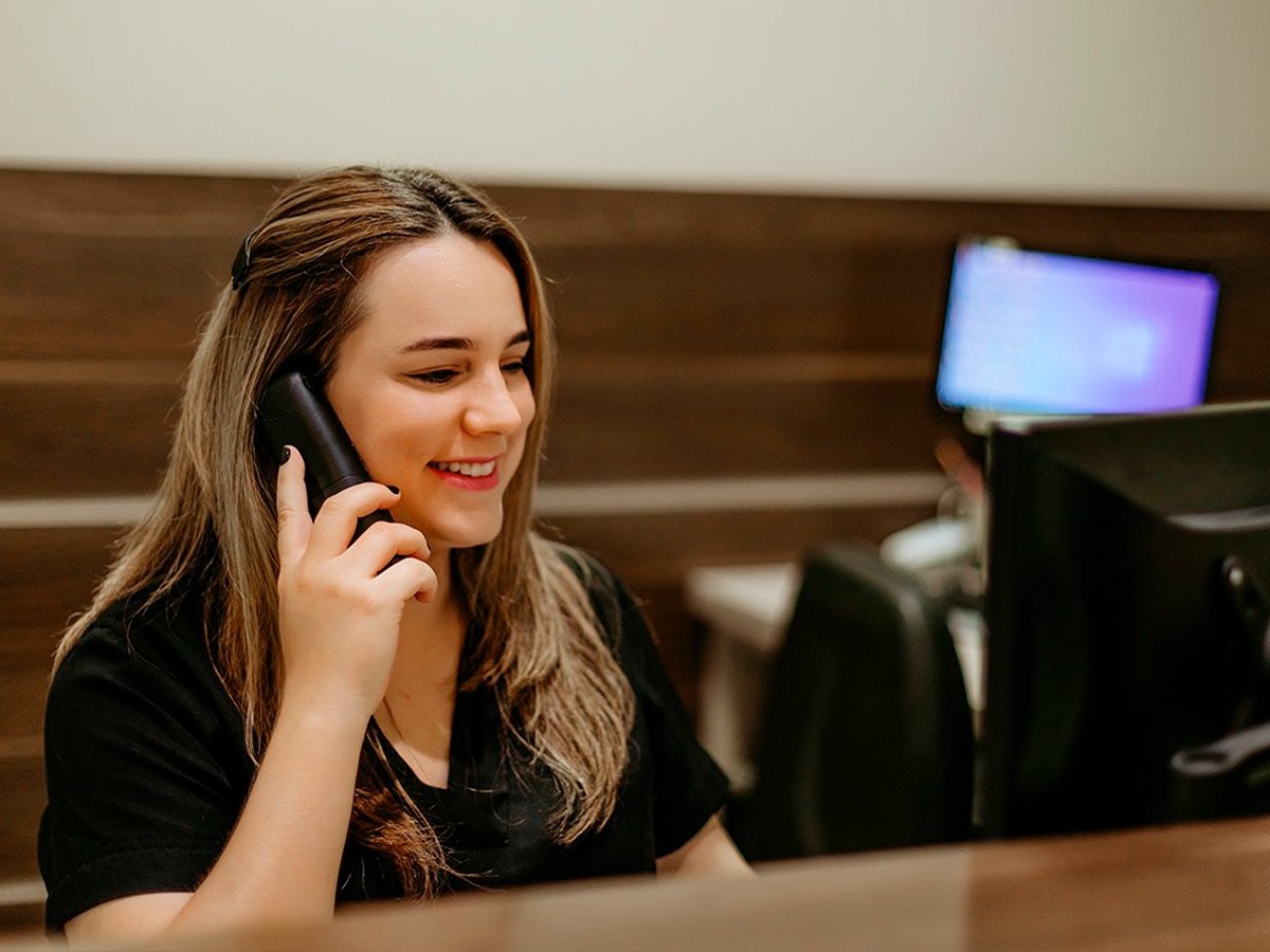 Recepcionista da Miers Odontologia atendendo ao telefone